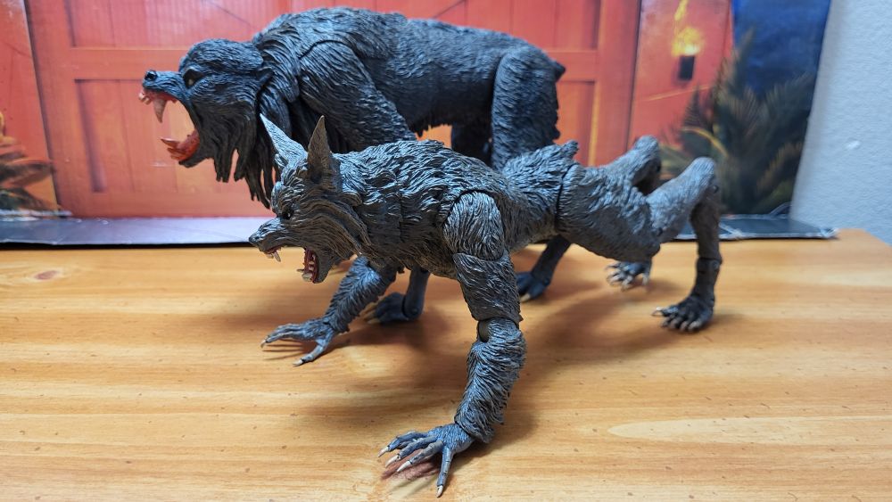 A comparison between NECA's The Howling Ultimate Werewolf, and the Ultimate Kessler Wolf. Side view, from the right, with both figures in a quadrupedal posture, with the Ultimate Kessler Wolf behind The Howling werewolf.